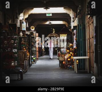 Mann im traditionellen qatari-gewand, der durch Souq Waqif in Doha, Katar wandert Stockfoto