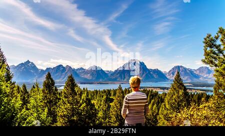 Frau, die vom Signal Mountain im Grand Teton National Park in Wyoming den Blick auf den Jackson Lake und die Berggipfel der Teton Range genießt Stockfoto