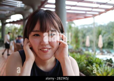 Eine schöne Dame, die sich in einem Restaurant am Pool entspannen kann. Stockfoto