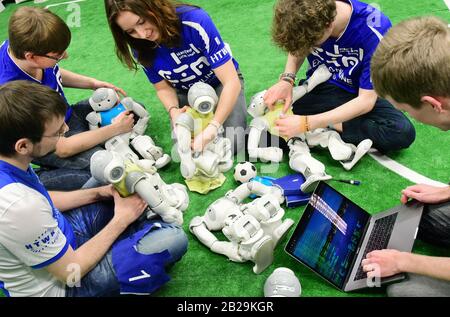 20. Februar 2020, Sachsen, Leipzig: Im Roboterlabor des Nao-Teams der HTWK haben die Mitglieder Andreas Kluge, Tobias Jagla, Carolin Gümpel, Felix Loos und Marvin Jenkel (l-r) die gelben und blauen Fußballtrikots für ein Testspiel aufgesetzt. Das Team, das 20 Bachelor-, Master- und Informatik-Mitglieder umfasst, bereitet sich derzeit auf die "Robo Cup German Open" in Magdeburg (24.-26.04.2020) und die Weltmeisterschaften der intelligenten Roboter im Juni (23.6.-29.06.2020) in Bordeaux (Frankreich) vor. Das Leipziger Roboterteam, das bereits mehrere Titel bei t gewann Stockfoto