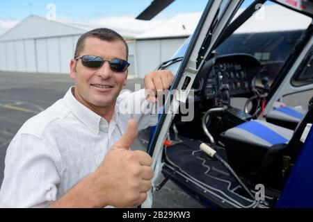 Mann Hubschrauberpilot zeigt Daumenauflauf Stockfoto
