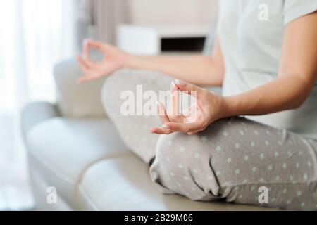 Nahaufnahme der Schwangeren, die Yoga praktizieren und zuhause meditieren Stockfoto