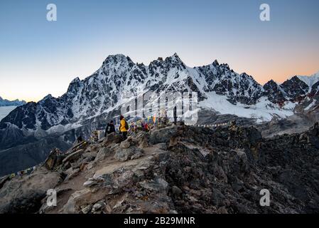 Menschen, die Sonnenaufgang bei Kala Patthar, dem höchsten Punkt der Wanderroute Everest Base Camp in Nepal, beobachten Stockfoto