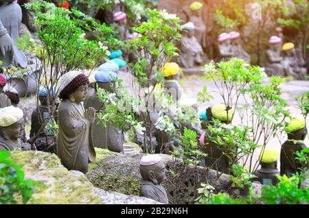 Stein Ksitigarbha Statuen (Jizo Bosatsu) in einem gestrickten Mützen, Daishouin (Daishou-in) Buddhistische Tempel, die heilige Insel Miyajima, Präfektur Hiroshima, Regi Stockfoto