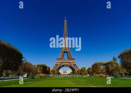 Eiffelturm mit Champs de Mars und sonniger blauer Himmel in Paris, Frankreich Stockfoto