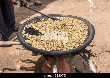 Braten von grünen, unreifen Kaffeebohnen auf einer flachen Pfanne bei einer Buna Wetten im Süden Äthiopiens Stockfoto