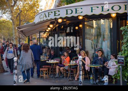 Die Leute, die im Freien im Café de Flore, einem berühmten Café in Paris, in Frankreich, Kaffee trinken Stockfoto