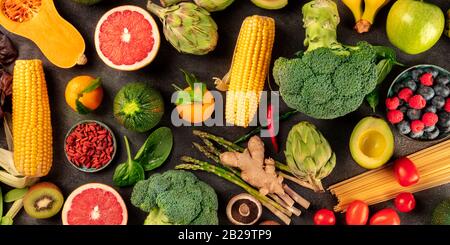 Veganes Speisepanorama, obenliegender Schuss aus frischem Obst, Gemüse, Pasta, Hülsenfrüchten und Pilzen, ein flacher Lay Stockfoto