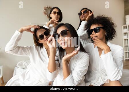 Portrait coole Mädchen mit Sonnenbrille und Bademänteln im Schlafzimmer Stockfoto