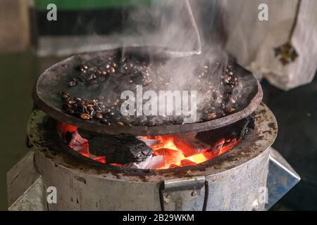 Braten von Kaffeebohnen auf einer flachen Pfanne in einem Haus im Süden Äthiopiens Stockfoto