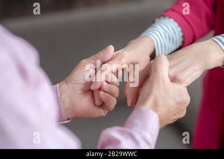 Nahaufnahme der Hände des Mannes, der die Hände der Womanen hält Stockfoto