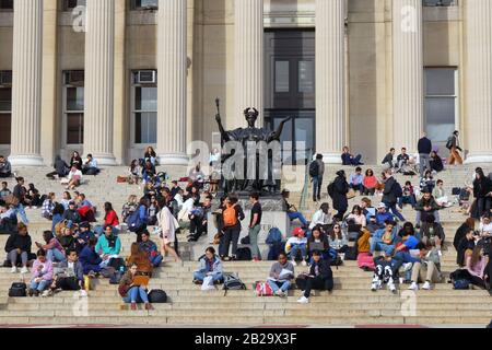 Studenten (und Alma Mater), die sich an einem warmen Wintertag, dem 24. Februar 2020, New York, New York, New York, auf den Stufen der Old Columbia University Library entspannen. Stockfoto