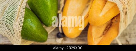 Frisches Brot, Avocado und Tomaten in einer wiederverwendbaren Tasche auf einer stilvollen Holzküche. Zero Waste Concept BANNER, LANGFORMAT Stockfoto