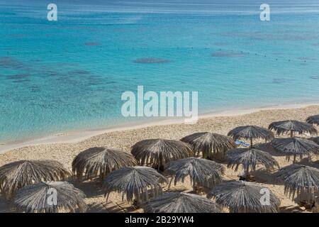 Blick auf den Strand mit Sonnenschirmen. Sonnenschirme werden aus Palmblättern hergestellt. Stockfoto