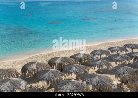 Blick auf den Strand mit Sonnenschirmen. Sonnenschirme werden aus Palmblättern hergestellt. Stockfoto