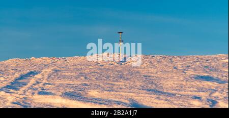 Veterne-Hügel-Gipfel mit Wegweiser auf dem Martinske Hole im Gebirge Mala Fatra in der Slowakei während der Winterdämmerung Stockfoto