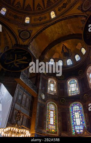 Verzierte Kuppel und bemalte Bögen, darunter eine Darstellung der Jungfrau Maria mit Jesus, mit später hinzugefügten islamischen Bannern, im Inneren des Hagia Sofia Museums, Stockfoto