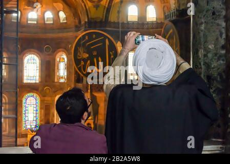 Ein Imam fotografiert mit einem Smartphone, während er das Hagia Sofia Museum, Istanbul, Türkei besucht Stockfoto