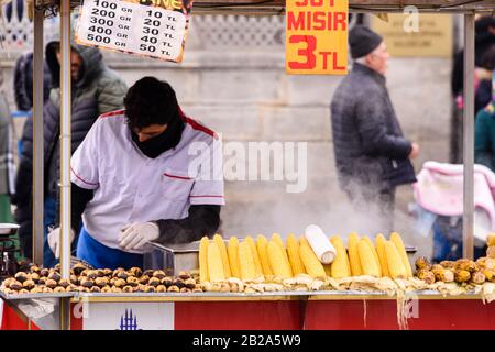 Straßenhändler, der geröstete Kastanien und Zuckermais aus einem Stall, Istanbul, Türkei, verkauft. Stockfoto