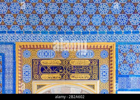 Verzierte Wandfliesen aus Keramik mit arabischen Zitaten aus dem Quran rund um eine Tür im Topkapi-Palastmuseum, Istanbul, Türkei Stockfoto
