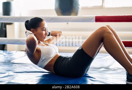 Fit Woman, die im Boxstudio Sport auf der Matte macht. ABS-Trainingstraining für Bauchmuskeln. Stockfoto