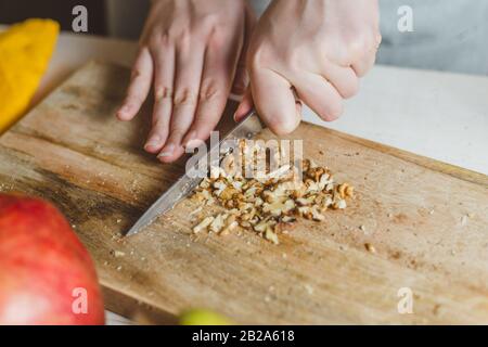 Walnuss Schneiden auf einem Holzbrett - selbstgemachtes Rezept - der hausfrau Hände-selektiven Fokus Stockfoto