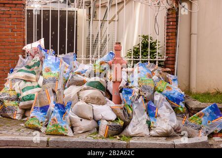 Plastiktüten, gefüllt mit Bausand, die auf einem Fußweg, Istanbul, Türkei, entsorgt wurden Stockfoto