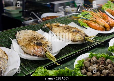 Gesalzene Fische mit Zitronengras, die auf einem Grillgrill in einem Straßenrestaurant, Bangkok, Thailand, gekocht werden Stockfoto