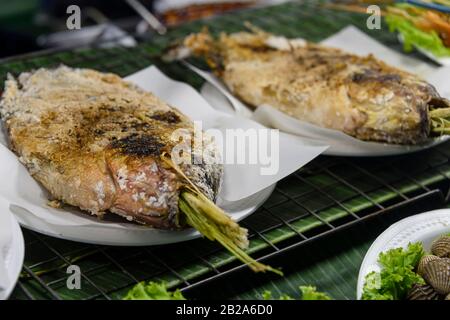 Gesalzene Fische mit Zitronengras, die auf einem Grillgrill in einem Straßenrestaurant, Bangkok, Thailand, gekocht werden Stockfoto