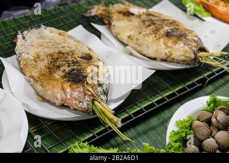 Gesalzene Fische mit Zitronengras, die auf einem Grillgrill in einem Straßenrestaurant, Bangkok, Thailand, gekocht werden Stockfoto