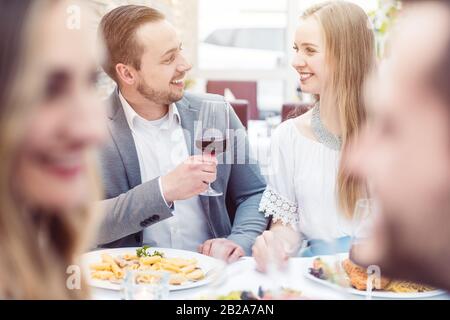 Fröhliche Leute genießen Getränke und Essen im italienischen Restaurant Stockfoto