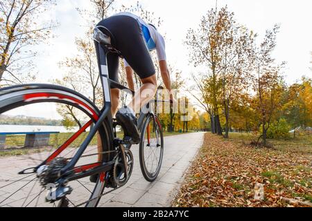 Junge Triathlet Radfahrer reiten Fahrrad im Herbst Park. Weitwinkelaufnahme mit Kopie Raum Stockfoto