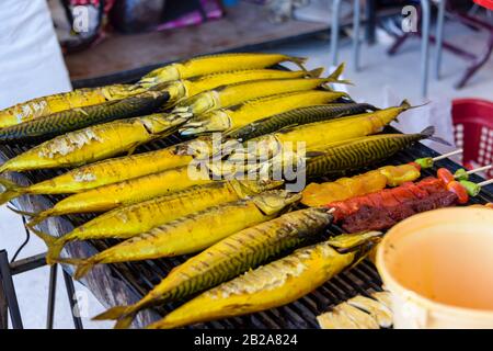 Makrelenrauchen über einem Grillgrill auf einem Straßennahrungsmarkt, Thailand Stockfoto