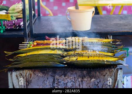 Makrelenrauchen über einem Grillgrill auf einem Straßennahrungsmarkt, Thailand Stockfoto