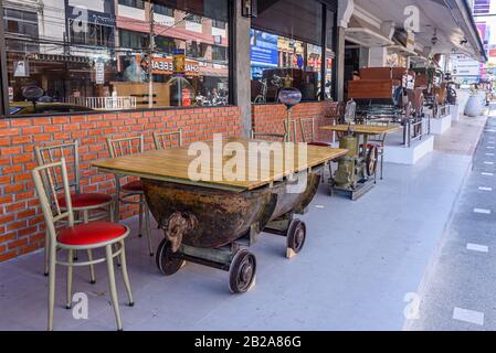 Tische aus Bergwagen mit halbem Fass vor einem Restaurant in Phuket, Thailand Stockfoto