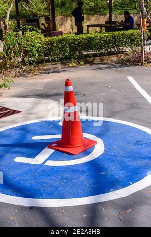 Verkehrshütchen auf frisch gestrichenen Fahrbahnmarkierungen für behindertengerechte Parkplätze. Stockfoto