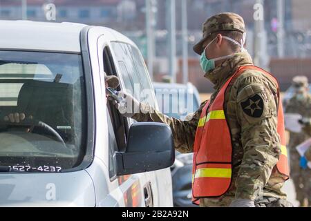 PYEOGTAEK, GYEONGGI, SÜDKOREA. März 2020. 2. März 2020-Pyeongtaek, South Korea-In diese Bilder wurden gemacht, ist US-Armee und Datum ist 27. Februar 2020. Abgebildet ist ein US-Soldat, der die Temperatur eines Autofahrers vor einem der Tore zur US-Army Garrison Humphreys, Südkorea, 27. Februar 2020 nimmt. Kredit: U.S. Army/ZUMA Wire/Alamy Live News Stockfoto