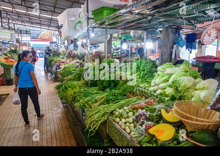 Eine Frau betrachtet einen Gemüsestall, der auf dem traditionellen Mae Somchit Kata Fresh Market, Kata, Phuket, Thailand, verkauft wird Stockfoto