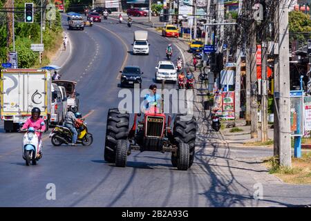 Ein alter Ford-Traktor fährt im Verkehr auf einer typischen Straße in Kata Dorf, Phuket, Thailand Stockfoto