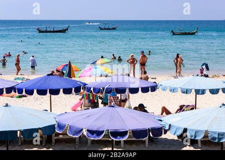 Blaue Sonnenschirme für Touristen am Strand von Kata Beach, Phuket, Thailand Stockfoto
