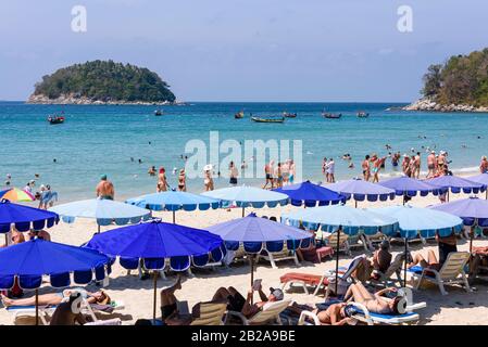 Blaue Sonnenschirme für Touristen am Strand von Kata Beach, Phuket, Thailand Stockfoto