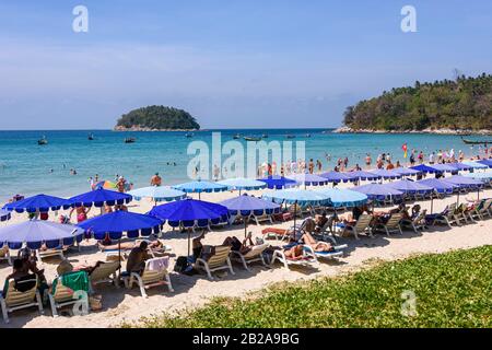 Blaue Sonnenschirme für Touristen am Strand von Kata Beach, Phuket, Thailand Stockfoto