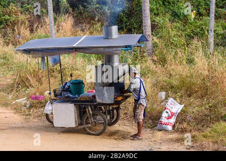 Ein Mann kocht Hühnerspieße auf einem mobilen Straßengrill, der auf einem Motorradbeiwagen, Phuket, Thailand, montiert ist Stockfoto