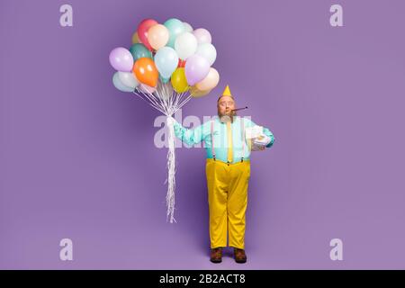 Foto in voller Größe schockiert verrückt Fett Mann halten Geschenkpaket Luftbaloons Pfeifen geräuschlos tragen türkis Teal Hemdschuhe glänzen Hosen pink Hosenträger Stockfoto