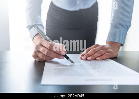Geschäftsfrau unterschreibt Vertragsdokument auf dem Schreibtisch und macht einen Deal. Stockfoto