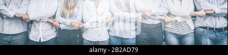 Kreative Teambesprechung verbindet sich. Junge Geschäftsleute halten sich die Hände. Einigkeit und Teamarbeit. Stockfoto