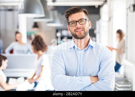 Porträt des jungen, selbstbewussten Führers, der im Amt steht. Neues Unternehmenskonzept für Start-up. Stockfoto