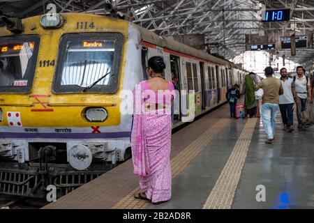 Mumbai, Indien - 29. Februar 2020: Indische Frau, die eine Sari trägt, wartet auf ihren Zug in Chatrapati Shivaji Terminus, das früher als Victoria Terminus i bekannt war Stockfoto