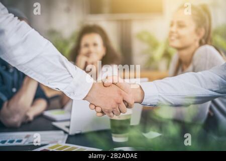 Geschäftsleute schütteln die Hände und beenden das Meeting. Erfolgreiche Geschäftsleute hakeln nach einem guten Deal. Stockfoto