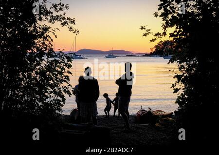 Silhouette einer Familie, die bei Sonnenuntergang Kajak fährt, San Juan Island, Washington Bay, USA Stockfoto